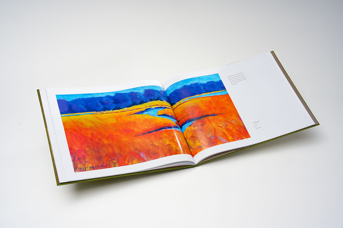 Open spread of coffee table art book featuring vibrant full-color contemporary landscape oil paintings on glossy 105lb pages