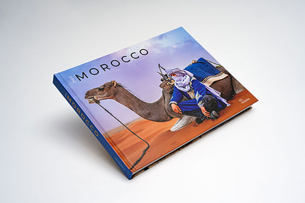 Hardcover travel photography coffee table book with matte lamination showcasing vibrant Moroccan landscapes and cultural images