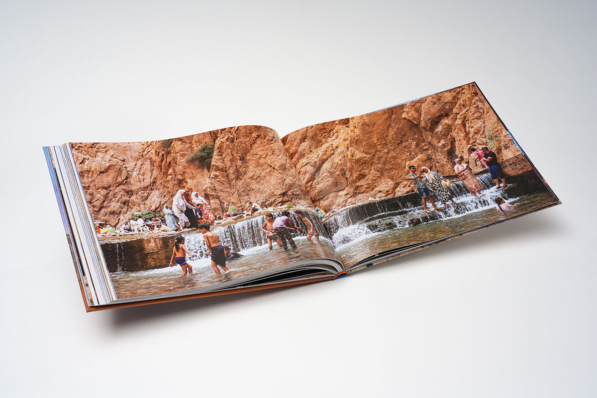 Flat-lay view of a hardcover travel photography coffee table book in 12x9 format, showcasing high-quality printing of Moroccan landscapes and cultural photographs