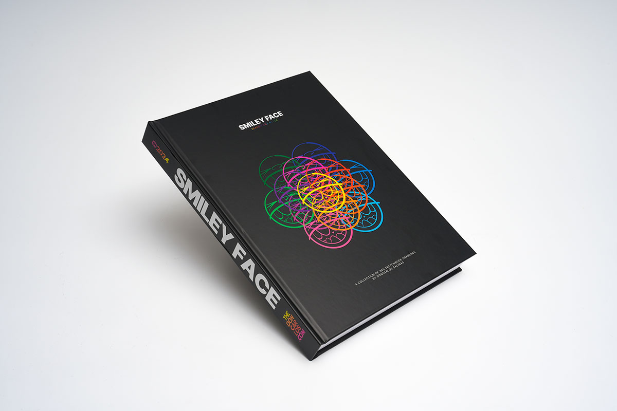 Hardcover sequential art sketchbook with matte lamination showcasing vibrant smiley face drawings