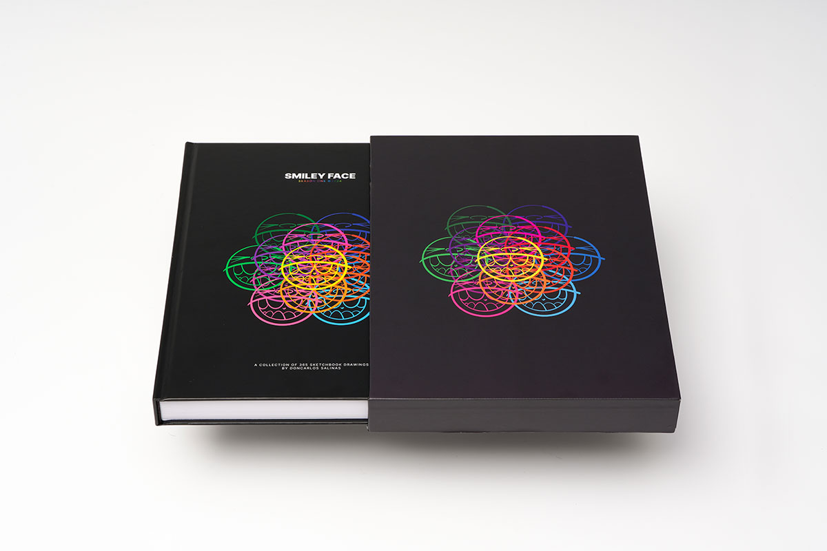 Flat-lay view of a hardcover sequential art sketchbook with 3.5mm hardboard slipcase featuring matte finish and UV coating