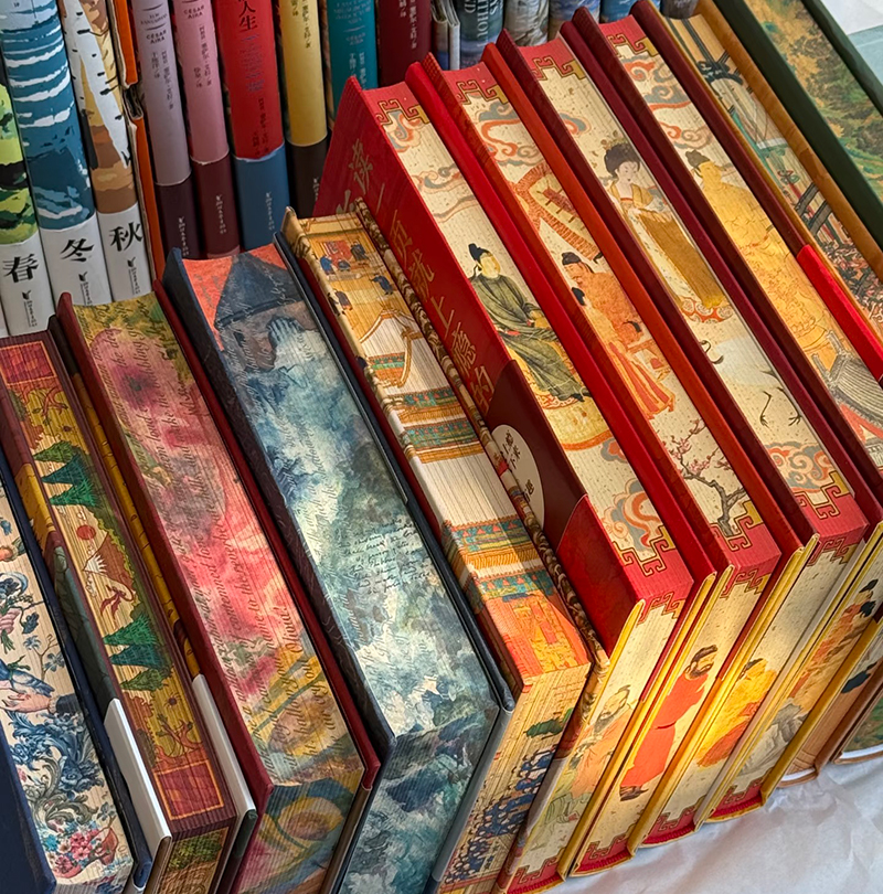 Collection of books featuring decorative printed page edges in various colors and patterns.