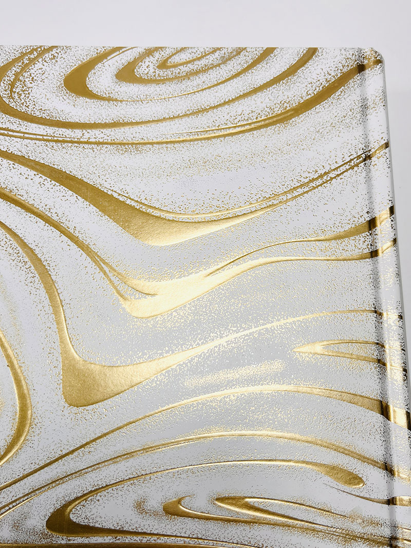 Image of foil stamping with an emboss effect on a book cover, featuring a shiny, metallic design with raised, textured elements