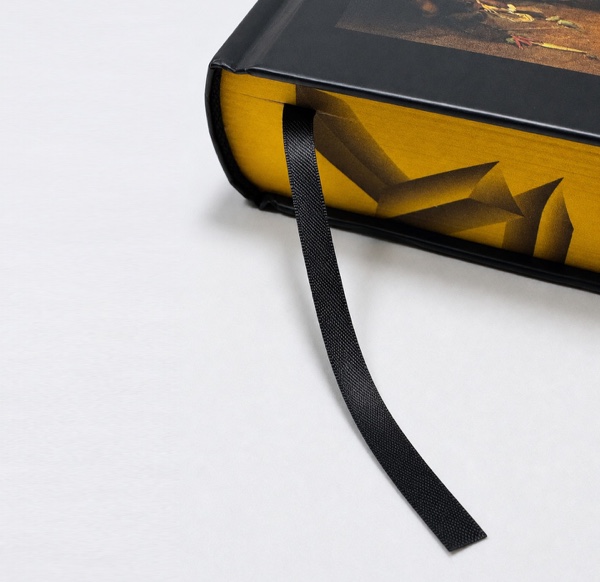 Black ribbon marker extending from a hardcover book