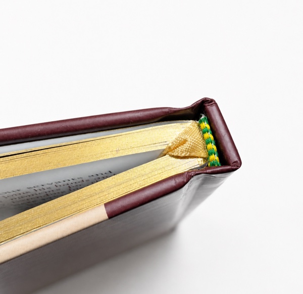 Gold ribbon marker attached at the spine of a hardcover book
