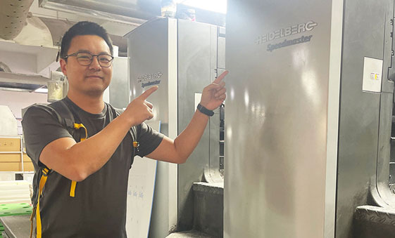 Ken standing beside a Heidelberg Speedmaster offset press