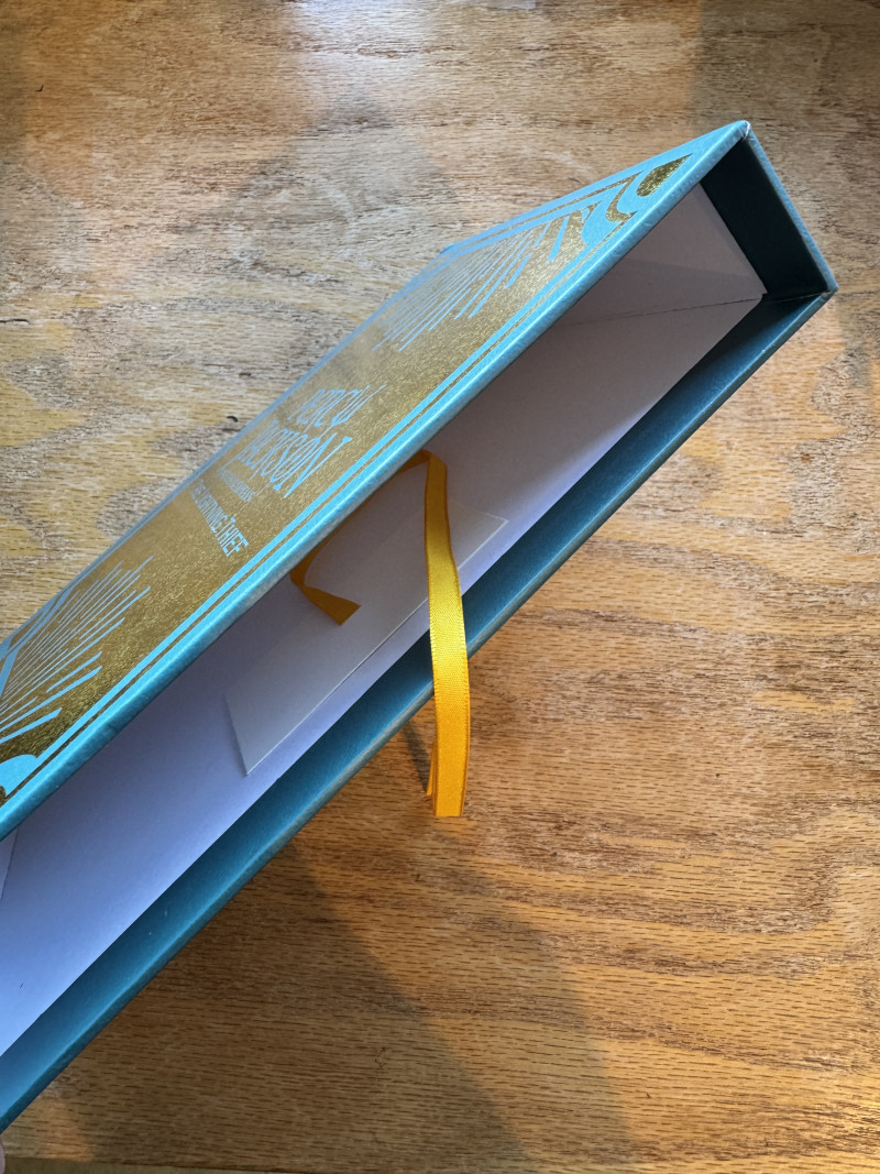 Book slipcase with golden ribbon pull-tab