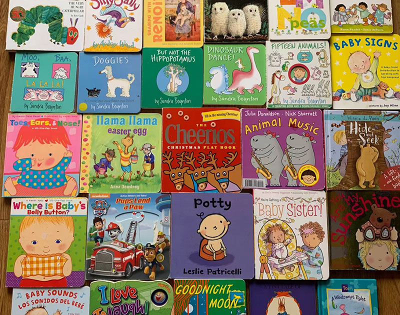 Various board books laid out on a table, displaying different cover designs and styles available on the market.