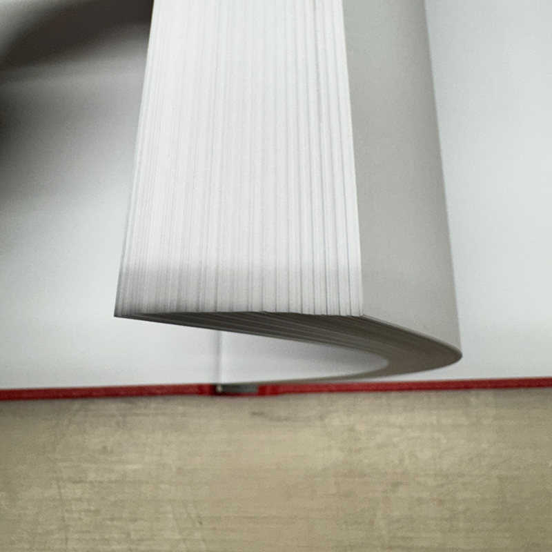 Book block bent at a 45-degree angle to create a flatter edge surface for edge printing.