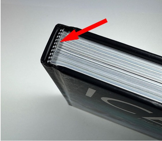 A red arrow pointing to a white and black striped headband in an art book